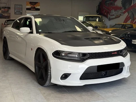 Showroom automobile intérieur avec véhicule Dodge Charger blanc et noir au premier plan