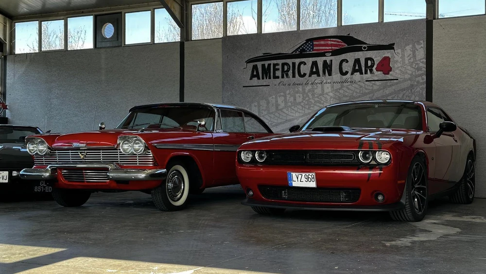 Showroom automobile couvert avec deux voitures américaines classiques rouges stationnées côte à côte