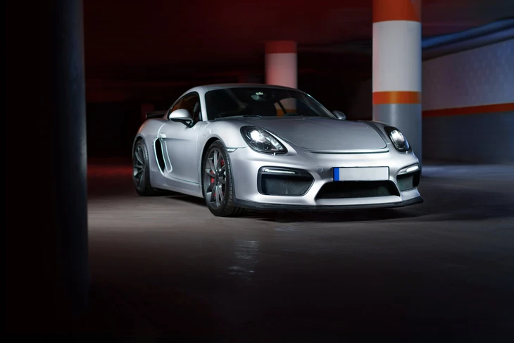 Showroom automobile intérieur avec véhicules neufs alignés sur sol carrelage brillant