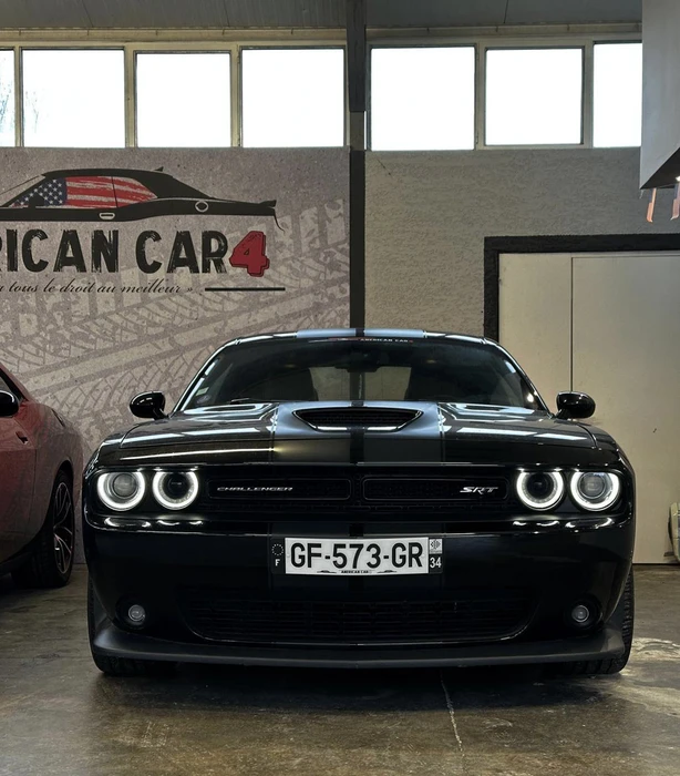 Extérieur, parking, véhicule Dodge Challenger orange et noir au premier plan