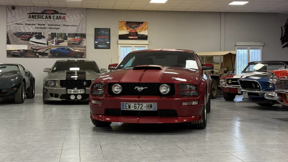 Véhicule sportif haut de gamme garé dans showroom automobile sur sol gris